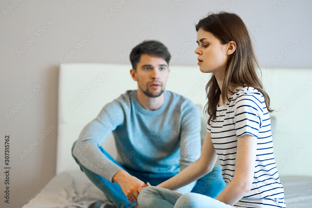 young couple sitting on sofa and looking at camera young couple sitting on sofa and looking at camera
