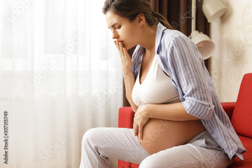 Pregnant woman at home feels sick photo