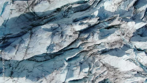 Slow and majestic aerial drone ascending view of the glacier of Sam Ford Fjord, Canada, near Greenland, with with high details of the glacier and the harsh rocky terrain