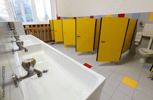 Fotografija taps of washbasin and yellow doors in the bathroom of a nursery