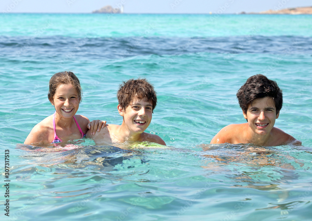 three smiling brothers in the clear water during a fun summer va