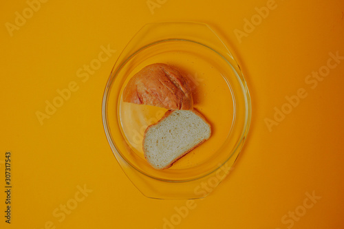 Diet and weight loss theme on the orange background. Bread on the glass plate.