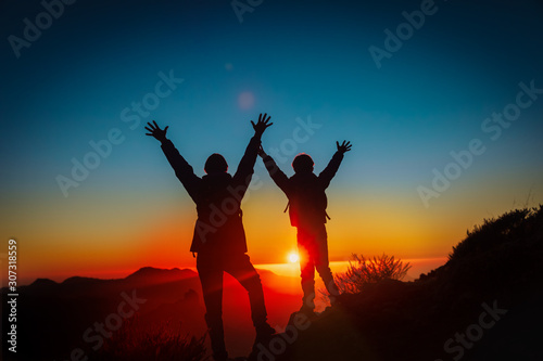 Father and son travel in sunset mountains, family hiking