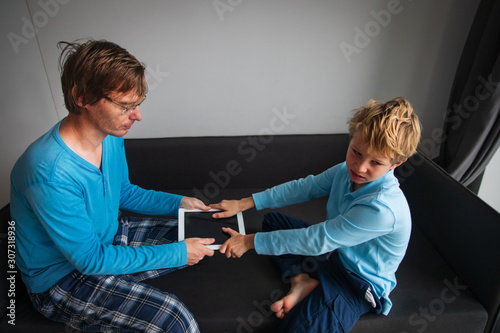 computer addiction- father taking touch pad from angry child