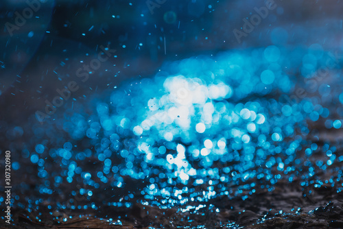 Autumn background with bokeh from the drops of rain  bright blue light is refracted through drops of water