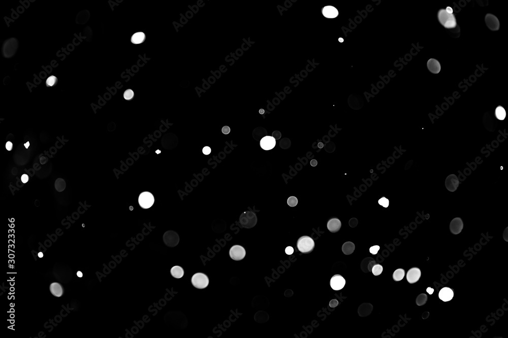 Texture of falling snow, volumetric snow bokeh on a black background Texture of falling snow, volumetric snow bokeh on a black background