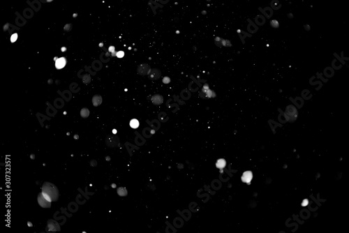 Texture of falling snow, volumetric snow bokeh on a black background