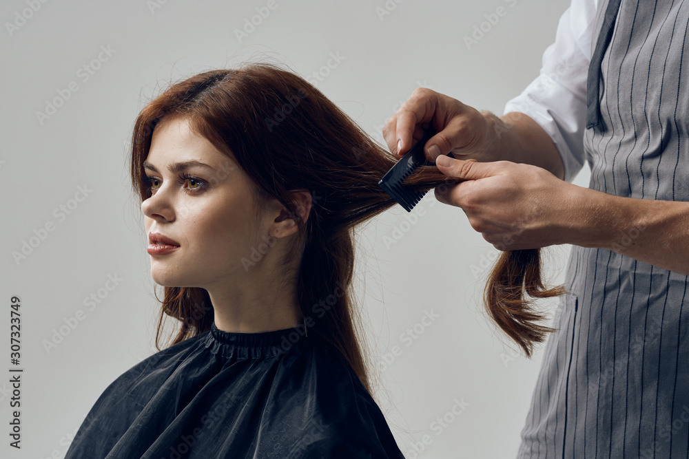 Fototapeta premium hairdresser cutting hair with scissors