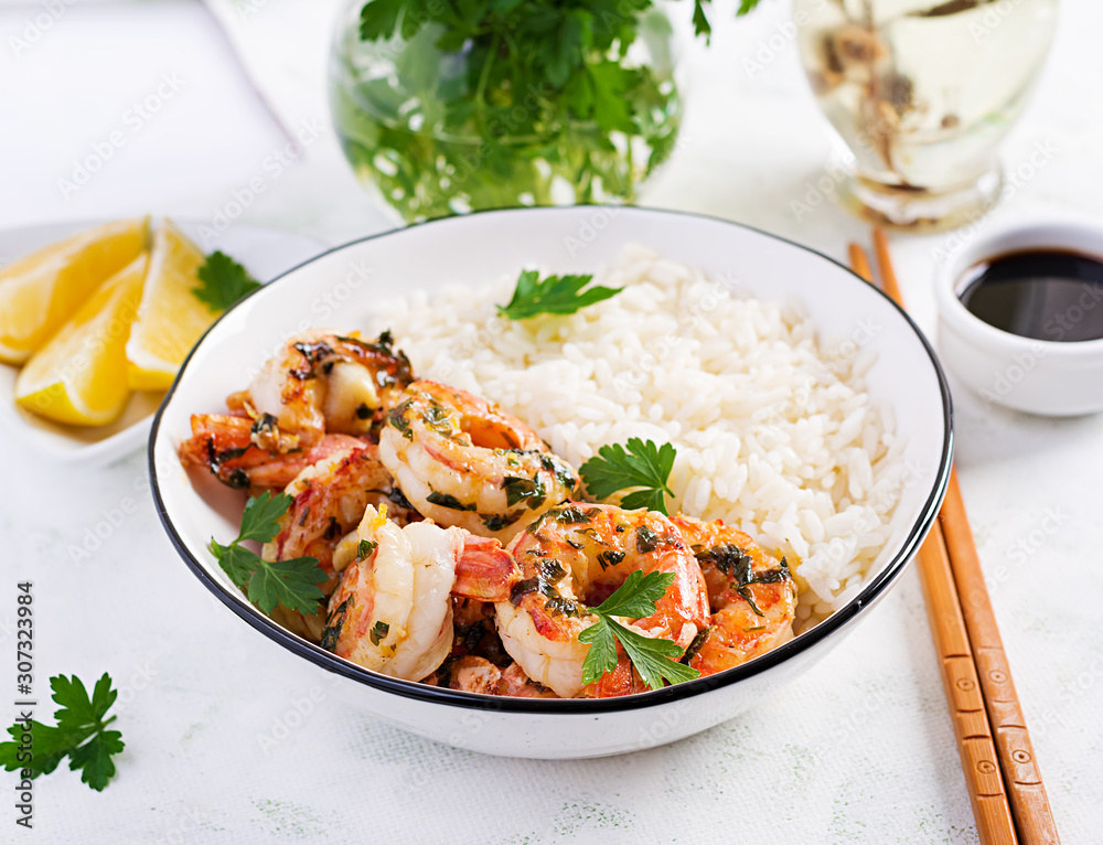 Grilled shrimps and boiled rice. King prawn tails in orange-garlic sauce with parsley. Grilled shrimps and boiled rice. King prawn tails in orange-garlic sauce with parsley.