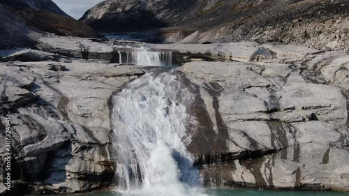 Slow aerial drone ride over waterfalls of the river near the Sam Ford Fjord, Canada, near Greenland, showing the huge volume of water that flow through this natural rocky terrain with relief