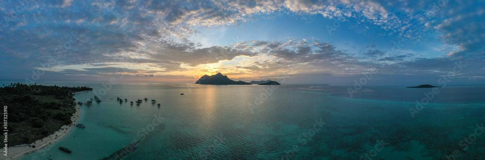 Aerial view of Sea Gypsy water village, island and the ocean with sky during sunrise in Semporna, Sabah, Malaysia, Borneo. Aerial view of Sea Gypsy water village, island and the ocean with sky during sunrise in Semporna, Sabah, Malaysia, Borneo.
