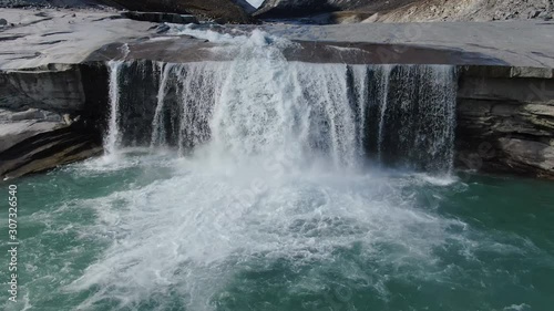 Slow aerial drone tilt view of the waterfalls by the river of the Sam Ford Fjord, Canada, near Greenland, showing the huge volume of water that flow through this natural rocky terrain with relief