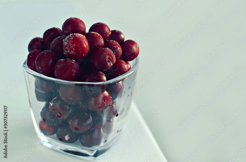 frozen cherry in glass on white background, copy space frozen cherry in glass on white background, copy space
