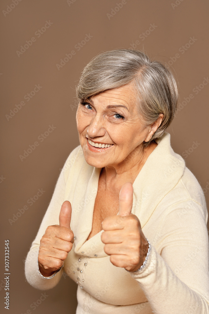 Close up portrait of beautiful senior woman with thumbs up Close up portrait of beautiful senior woman with thumbs up