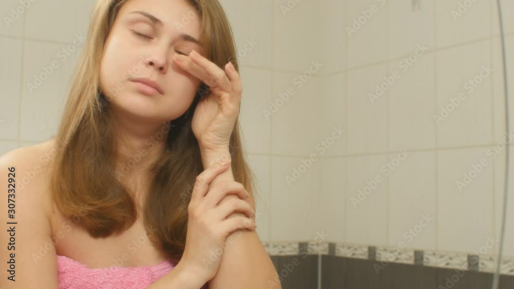 young woman in the bathroom preens and doing makeup, girl in morning routine, concept cosmetics and female beauty young woman in the bathroom preens and doing makeup, girl in morning routine, concept cosmetics and female beauty