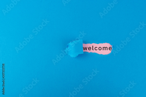 Torn paper with the word welcome underneath photo