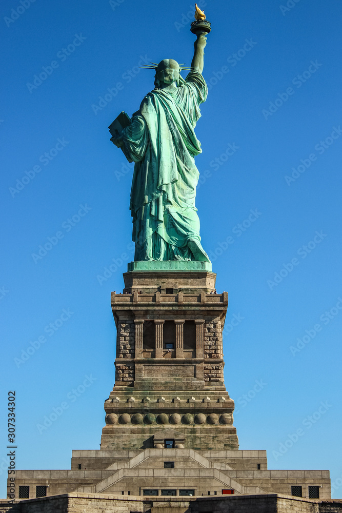 Statue of Liberty back side on a clear blue sky day, Ellis Island, New York, United States of America.