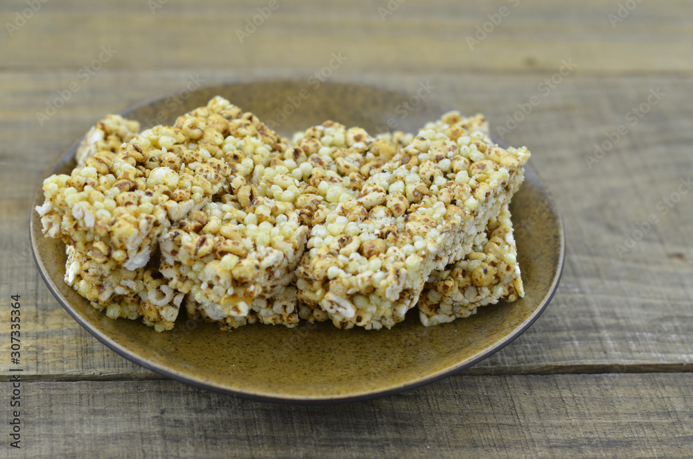 Cereal bars in brown plate on wooden background. Cereal bars in brown plate on wooden background.