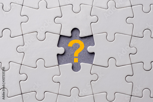 Orange question mark placed on last piece of jigsaw puzzle