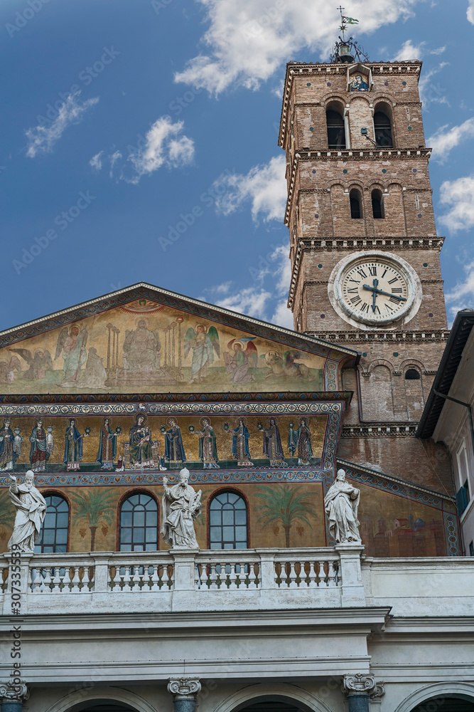 facade of the Cathedral of the Blessed Virgin Mary the Great with a beautiful clock tower in the Italian capital