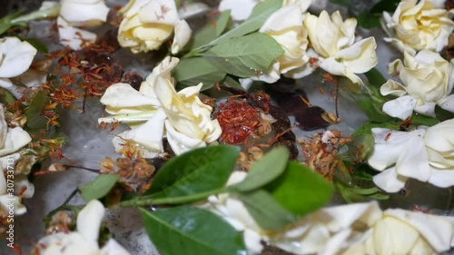 Big cup ( salung ) filled with holy turmeric water along with Cape Jasmine and sompoi, Acacia concinna, for Rod Nam Dam Hua ceremony, paying respect to the elders, during Songkran festival in Thailand photo