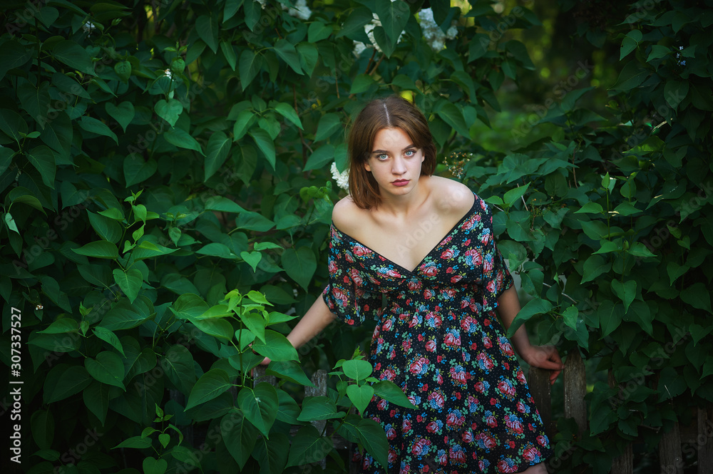 Portrait of a young girl in the Park on the background of greenery Portrait of a young girl in the Park on the background of greenery