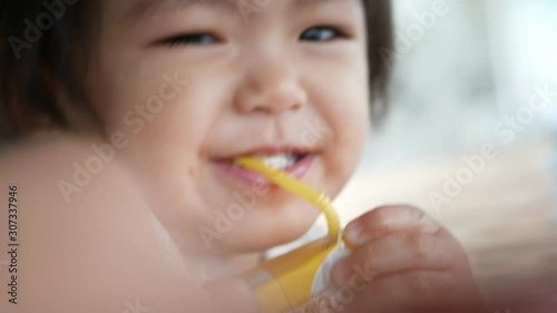 Little cute Asian, Thai, baby girl, 2 years old, playing with a camera, trying to touch it, while she was being filmed