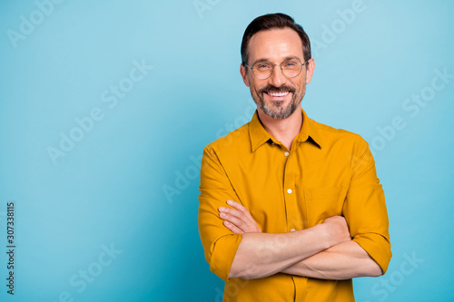 Portrait of charming mature man true boss feel content emotions wear yellow shirt isolated over blue color background photo