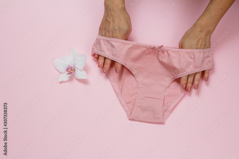 Women's hands with beautiful panties on pink background. Women's hands with beautiful panties on pink background.