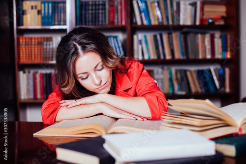 girl is preparing for the exam in the library reads books photo