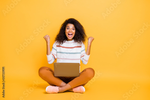 Photo of excited funky cheerful emotional crazy hipster enjoying success holding netbook on legs isolated bright color background