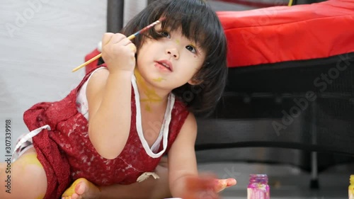 Little baby girl, 26 months old, enjoys painting her own hand at home - baby handprint / fingerprint painting