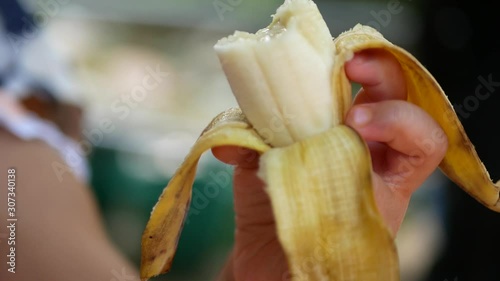Ripe banana in a baby girl's hand being eaten - toddler eats fruit
