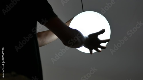 A live ceiling lamp in an electrician hands being installed