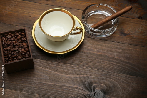 cigar with coffee beans on wooden surface with copy space