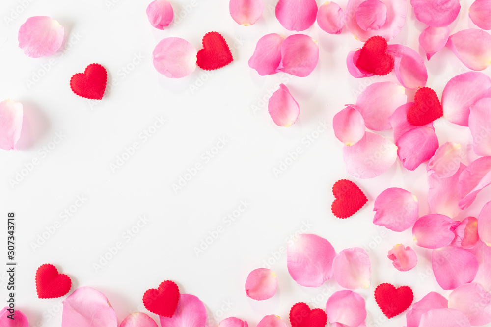 Top view of pink rose petals and red heart on white background.Valentine's day concept. Top view of pink rose petals and red heart on white background.Valentine's day concept.