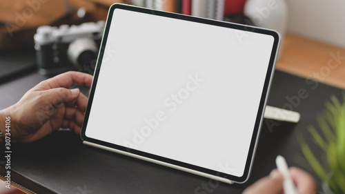 Cropped shot of businessman using blank screen tablet in modern office room