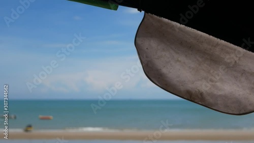 Selective focus beach umbrella moving on a breezy day at a beachside with defocus view of a sea and blue sky in the background
