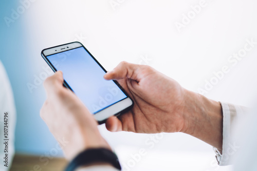 Anonymous manager using smartphone with empty screen