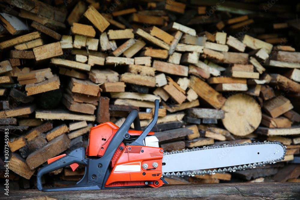 chainsaw on the background of firewood with copy space