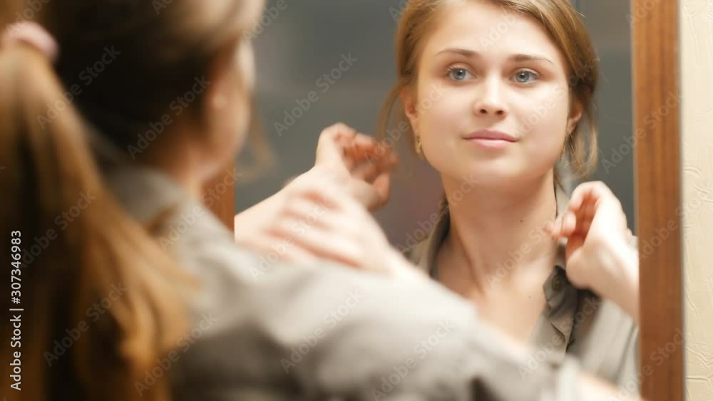 reflection of a cute girl preens herself in front of a mirror at home,beautiful young woman straightens her hair, concept female beauty and fashion reflection of a cute girl preens herself in front of a mirror at home,beautiful young woman straightens her hair, concept female beauty and fashion