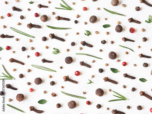 Creative decorative food composition of various spices and fresh herbs on white background.