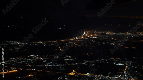 View of a city at night from an airplane's window before the plane landing