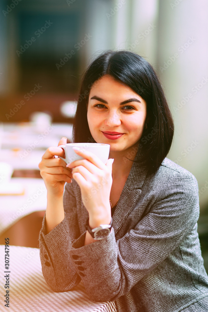 Portrait of young beautiful woman sitting in a cafe outdoor drinking coffee. Portrait of young beautiful woman sitting in a cafe outdoor drinking coffee.