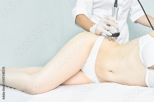 Perfect body radio treatment. Woman at spa procedure. Doctor hand and girl body. RF cosmetology lifting. Legs