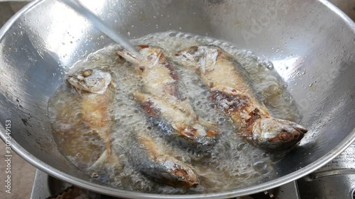 Pan fried shortbodied mackerels ( Rastrelliger brachysoma ) in a boiling cooking oil