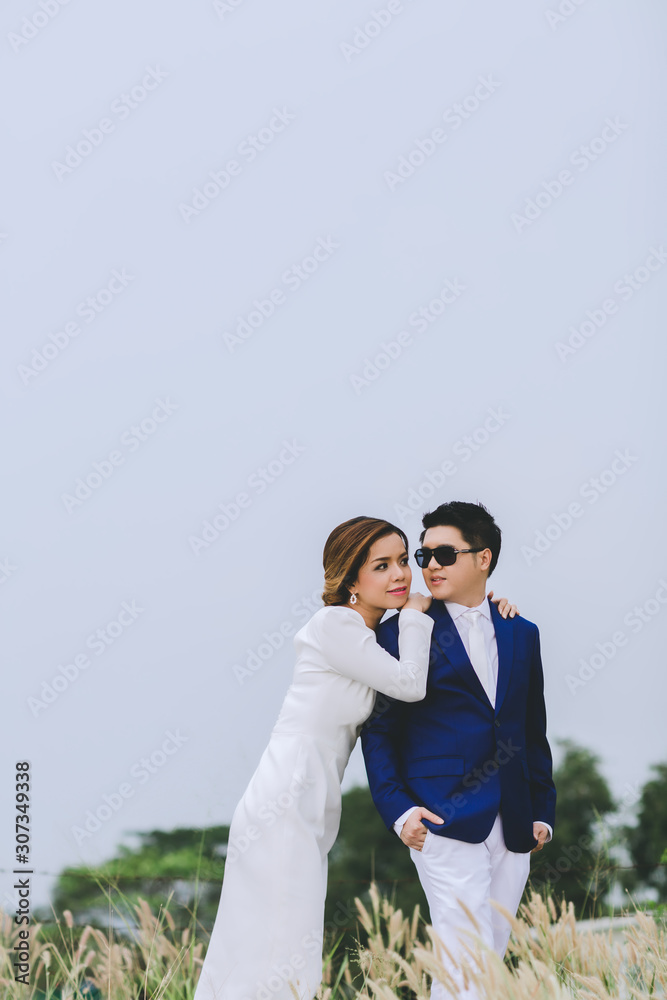 Young asian groom and bride posing and smiling for pre-wedding shot Young asian groom and bride posing and smiling for pre-wedding shot
