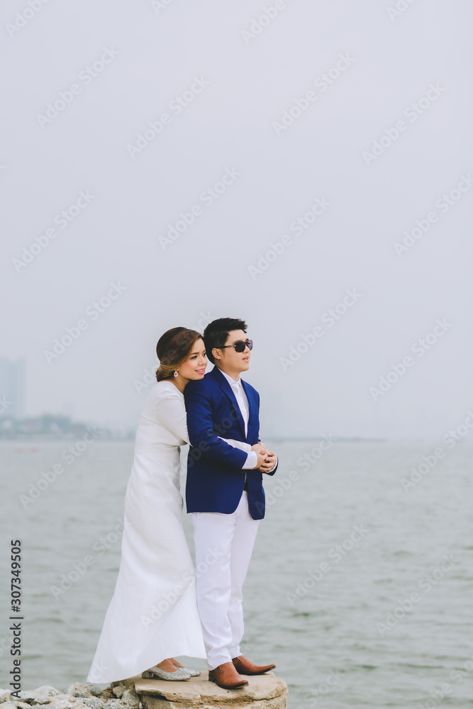 Young asian groom and bride posing and smiling for pre-wedding shot Young asian groom and bride posing and smiling for pre-wedding shot