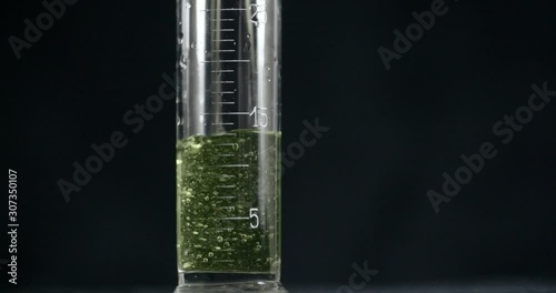 an old chemical test tube syringe is filled with chemicals in a medicine laboratory hospital drugs creating a reaction resin synthetic experiment chemistry class modern isolated on black background