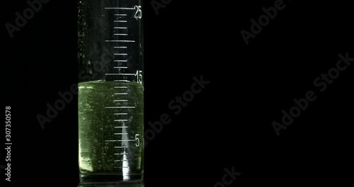 an old chemical test tube syringe is filled with chemicals in a medicine laboratory hospital drugs creating a reaction resin synthetic experiment chemistry class modern isolated on black background